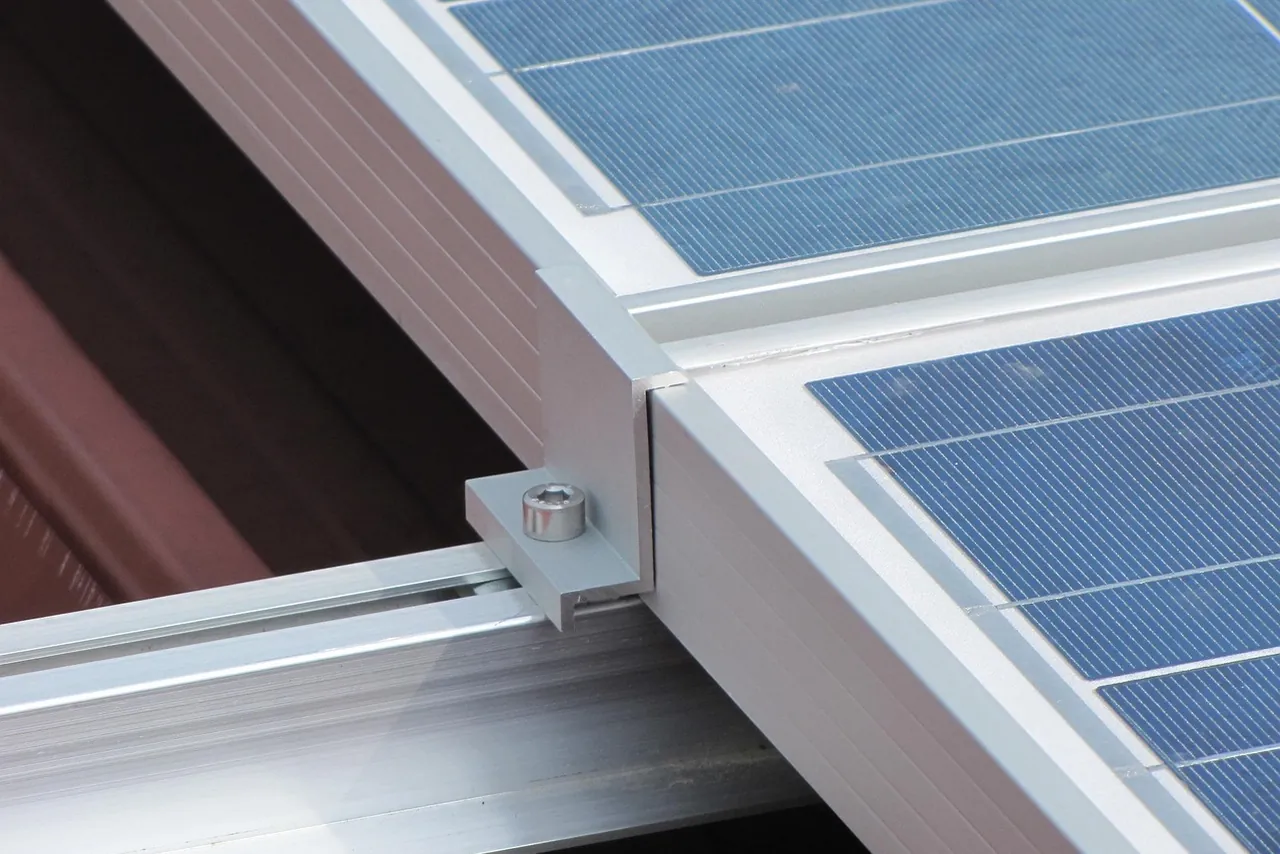Modulklemme mit Schraube fixiert zwei Solarmodule auf einer Montageschiene aus Aluminium (Trautskirchen, Landkreis Neustadt an der Aisch-Bad Windsheim)