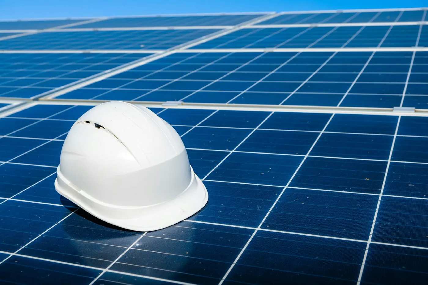 Weißer Schutzhelm liegt auf den blauen Solarmodulen einer Photovoltaikanlage (Meerdorf, Landkreis Peine)