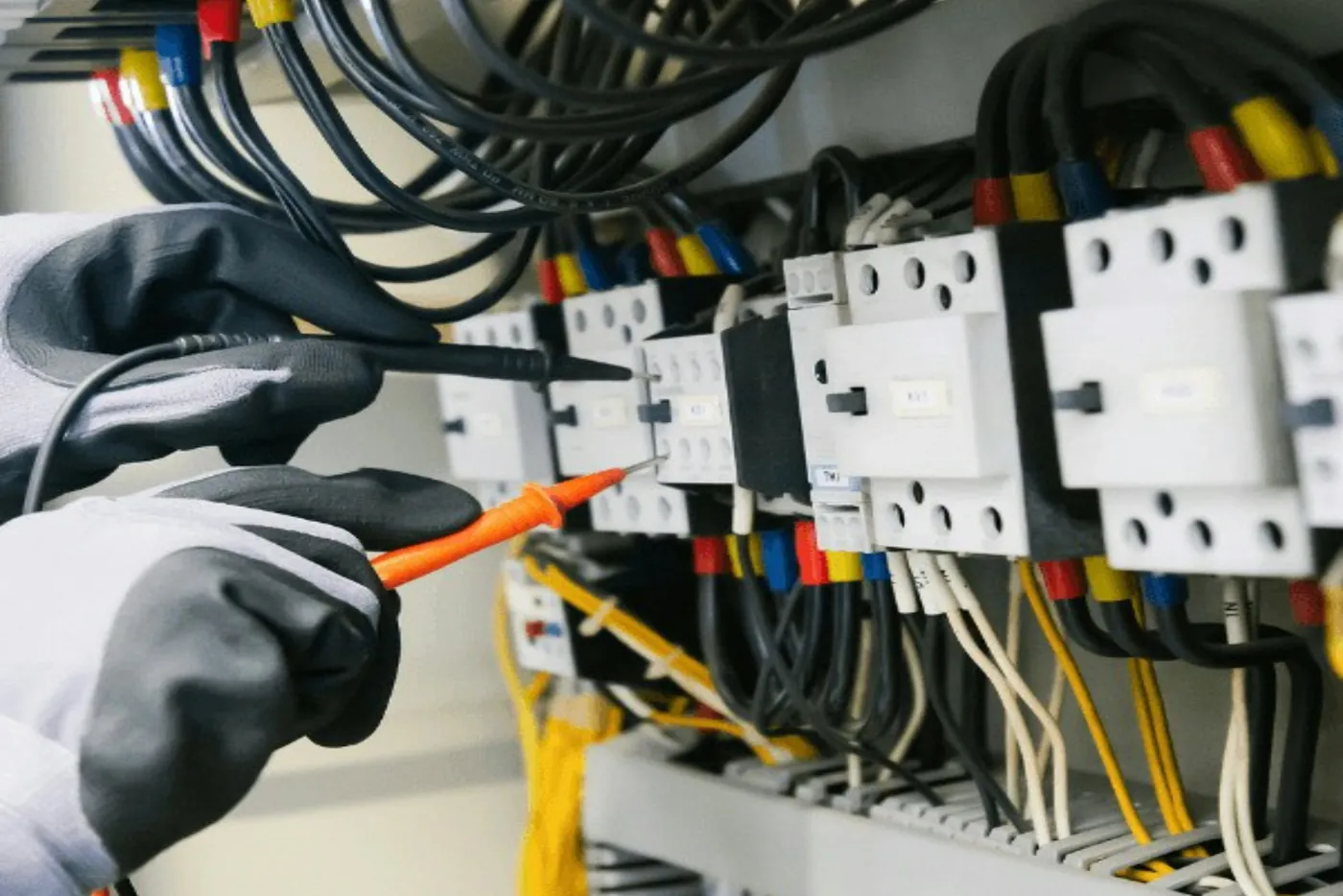 Elektriker prüft mit den Messspitzen eines Messgeräts die Klemmen von Schützen im Schaltschrank (Schwäbisch Hall)