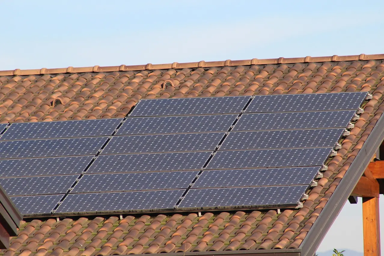 Solarmodule in zwei Reihen auf einem roten Ziegeldach vor blauem Himmel (Krummesse, Kreis Herzogtum Lauenburg)