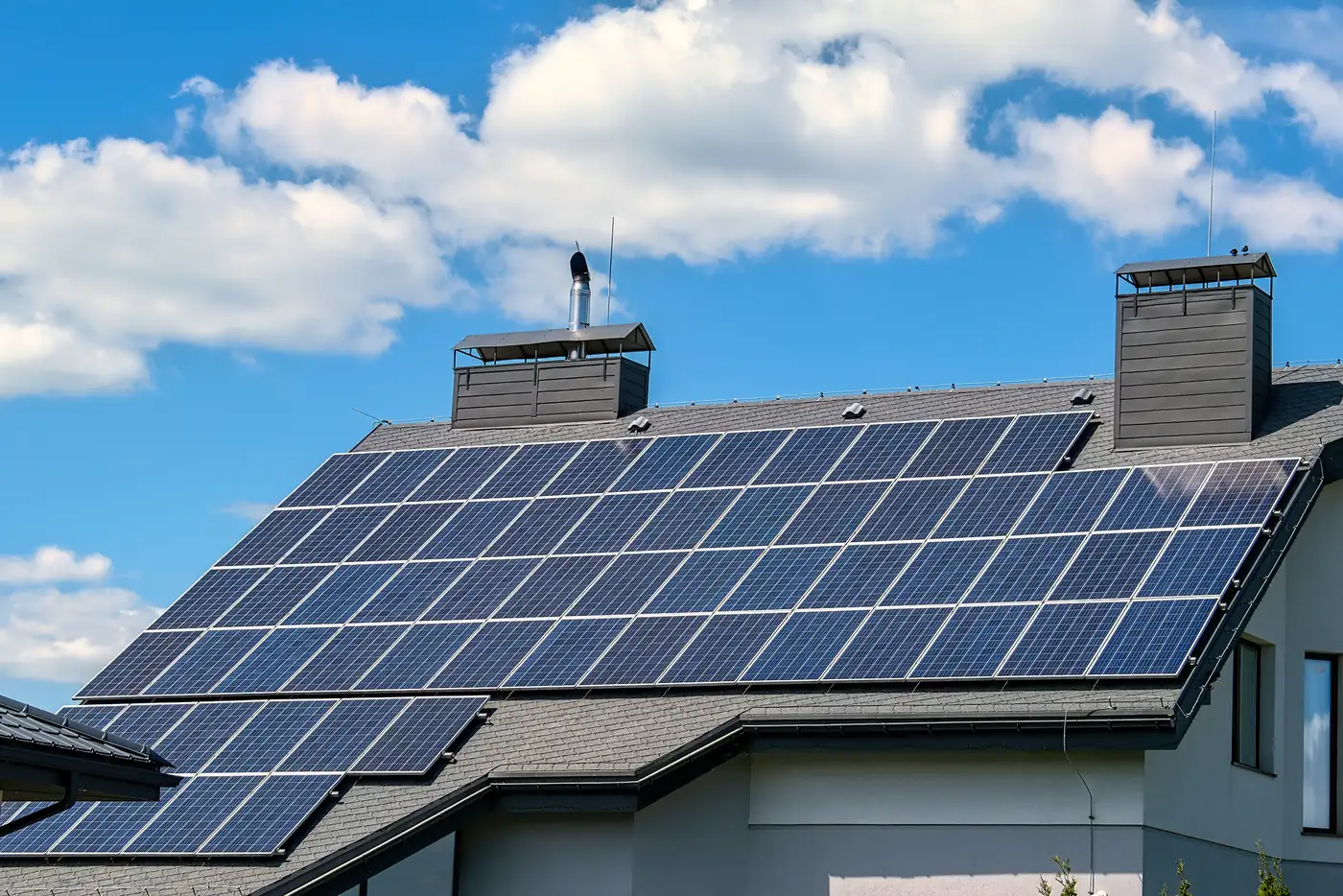 Großflächige Solaranlage auf dem grauen Dach eines modernen Hauses mit zwei Schornsteinen (Sennewitz, Saalekreis)
